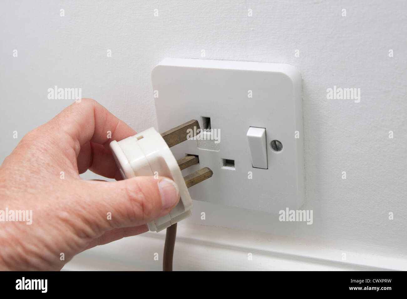 Hand, Stecker in die Steckdose 3-polig Stockfoto