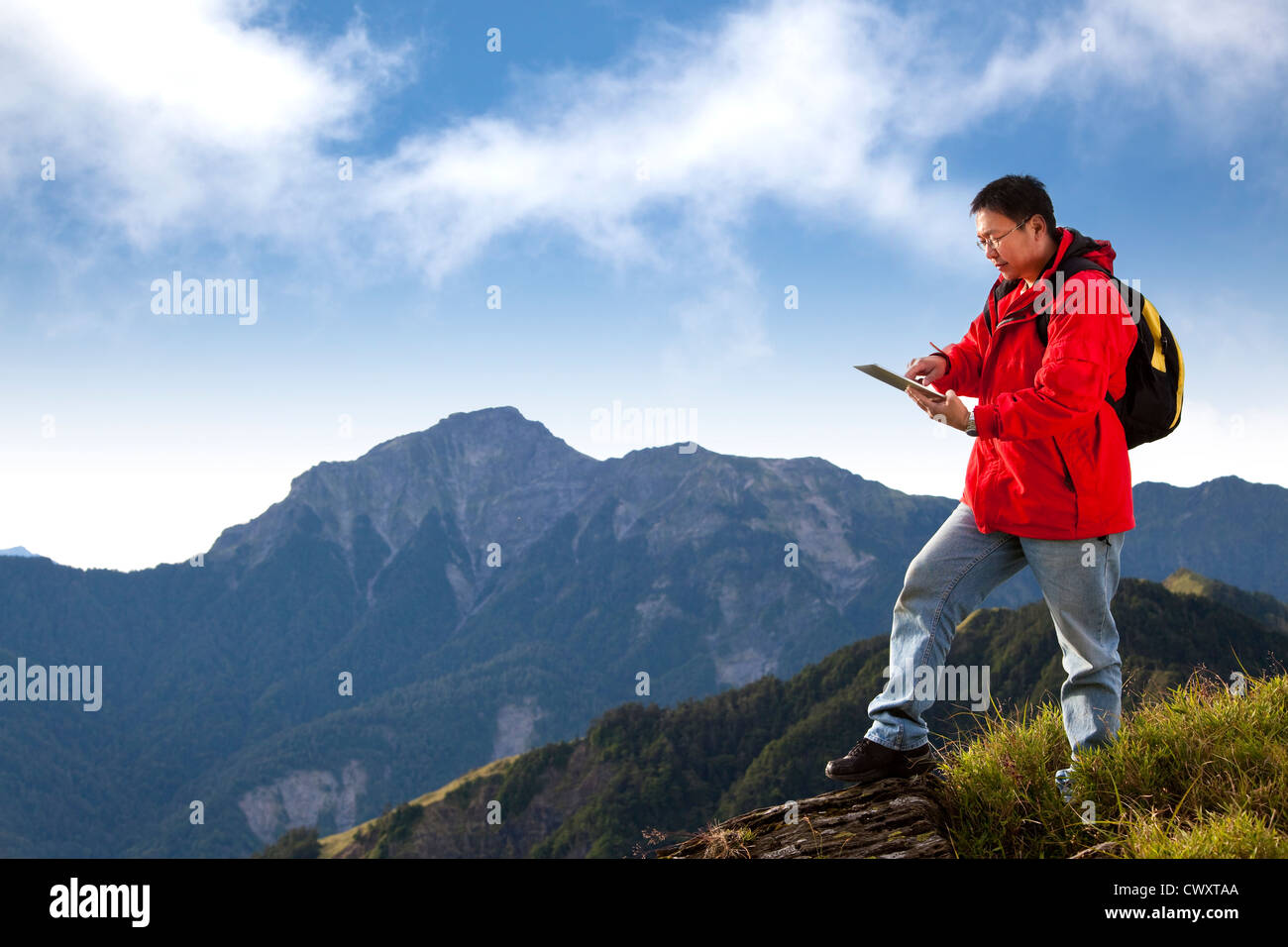 junger Mann berühren den Tablet-pc auf Berg Stockfoto