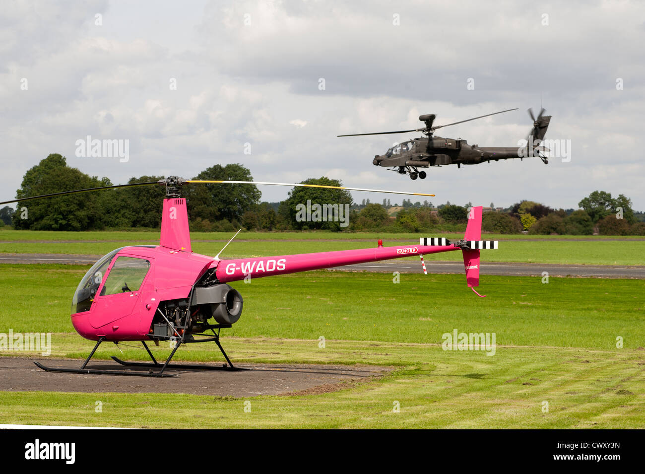 Kleine "und" Large - Robinson R22 Beta und RAF Apache Angriff Hubschrauber Anteil Wolverhampton Flughafen.  SCO 8373 Stockfoto