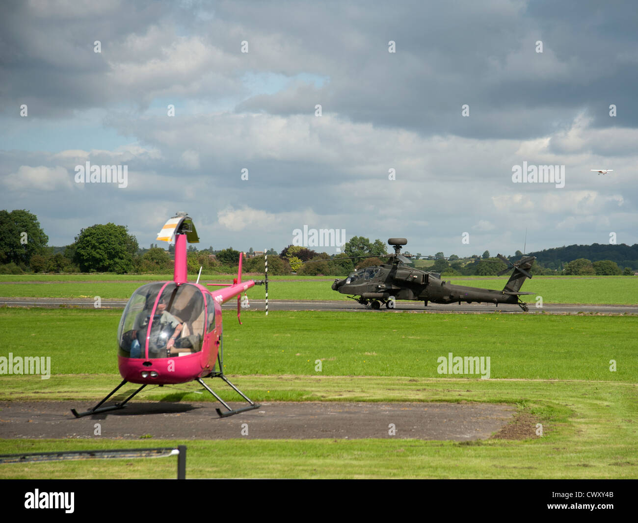 Kleine "und" Large - Robinson R22 Beta und RAF Apache Angriff Hubschrauber Anteil Wolverhampton Flughafen.  SCO 8376 Stockfoto