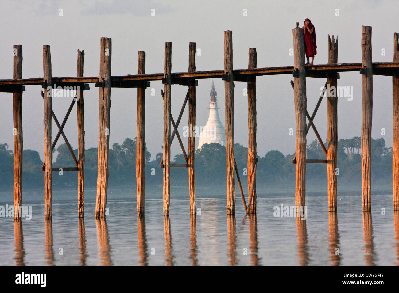 Myanmar, Burma, Mandalay, Amarapura. Burmesische Mönche Walking Home über die U Bein Brücke am Ende des Tages. Stockfoto