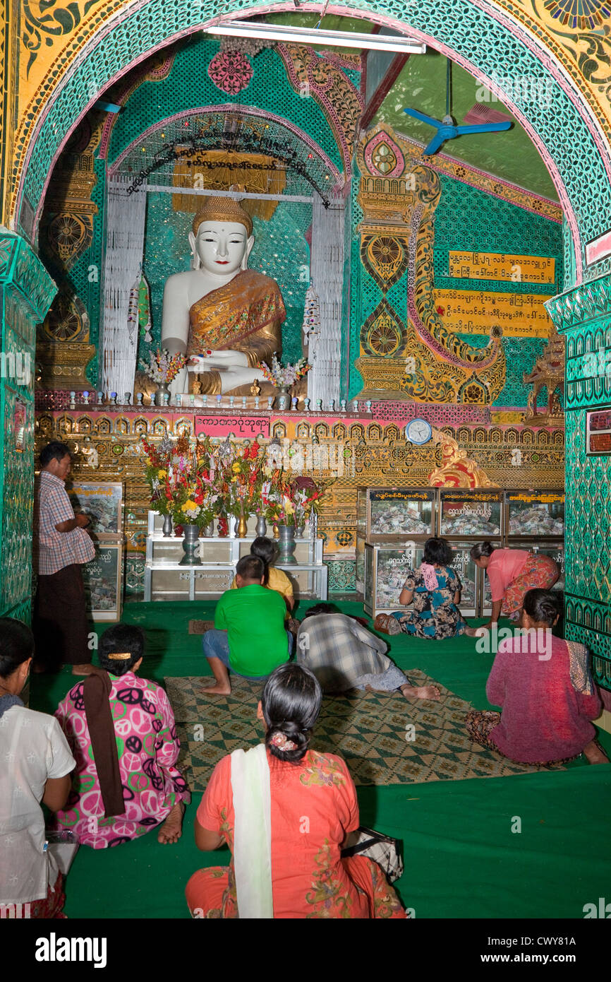 Myanmar, Burma. Sutaungpyei-Pagode, Mandalay Hill Tempel. Gläubige beten vor der Buddha-Statue. Stockfoto