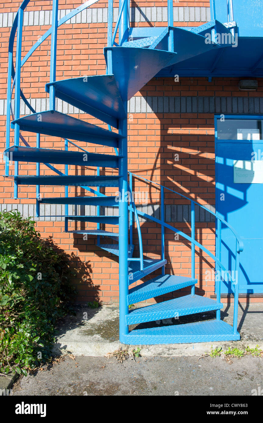 Blau lackierten Stahlspirale Treppe Feuertreppe auf Seite des Industriebaus Stockfoto