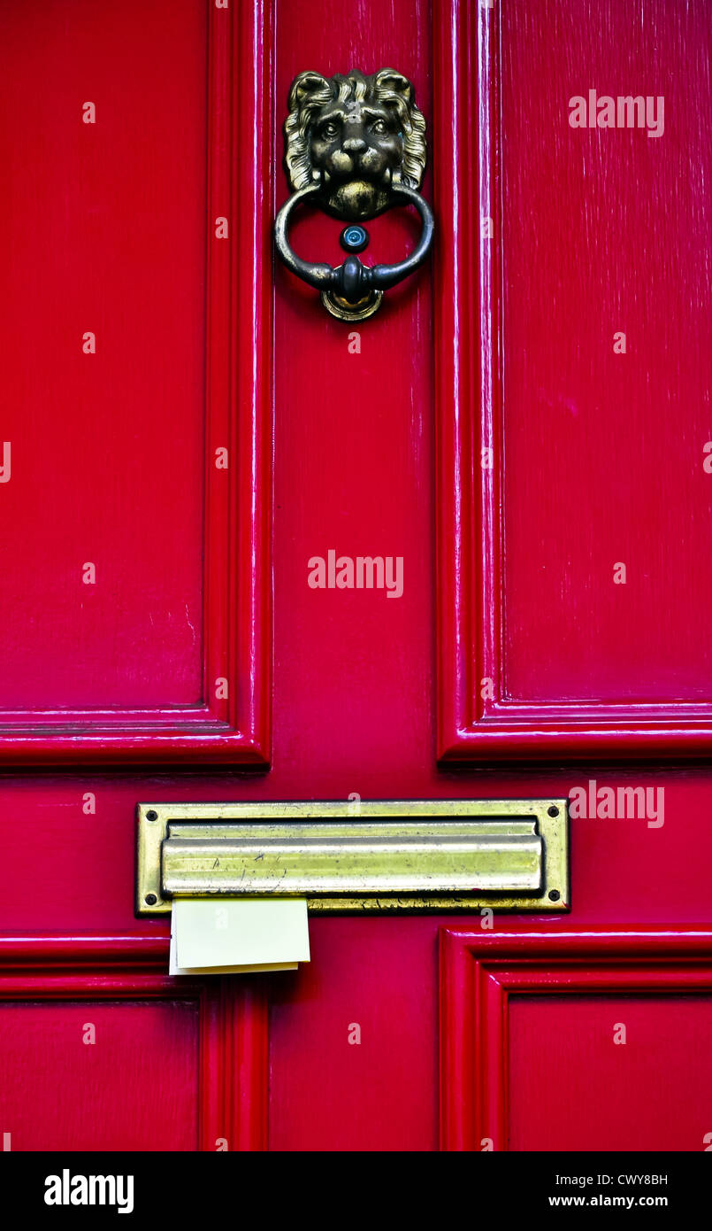 roter Holztür mit Messing Türklopfer und Briefe in den Briefkasten zu stecken Stockfoto