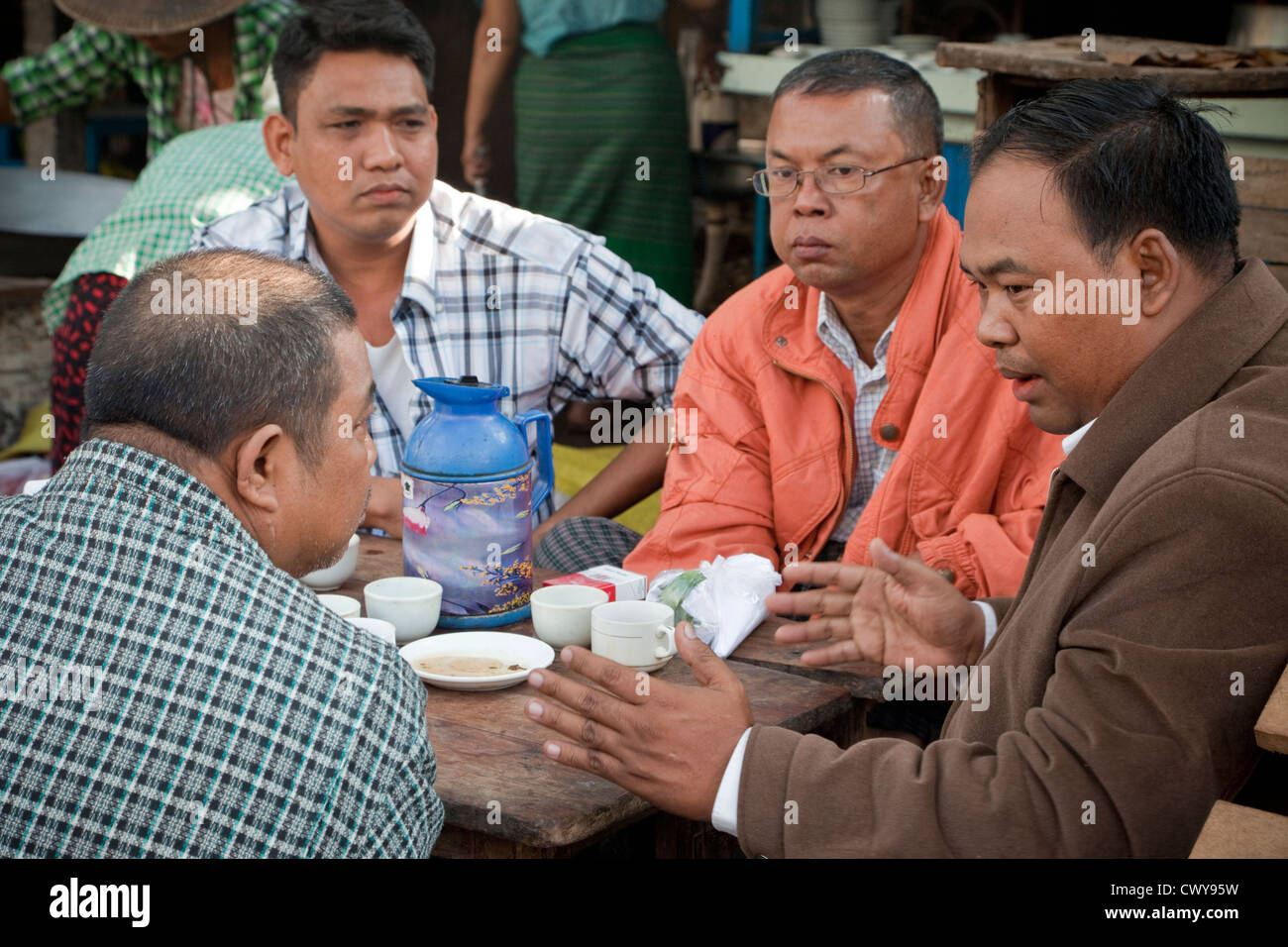 Myanmar, Burma. Mandalay. Burmesische Männer sprechen in einem Café. Stockfoto