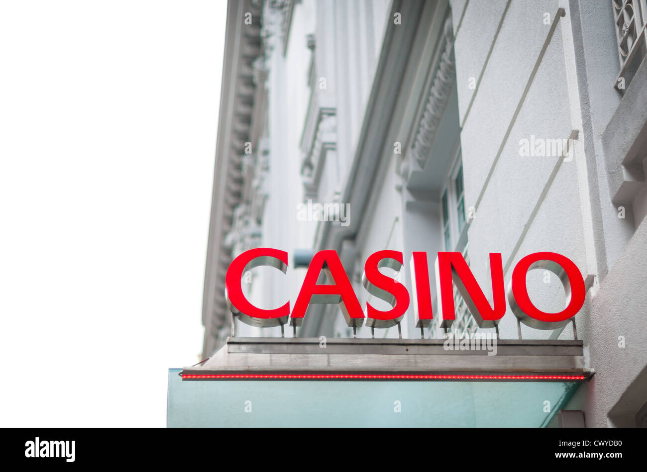 Schild mit Casino darauf geschrieben. Rote Buchstaben des Textes kontrastieren mit weißen Gebäude. Schönes Haus mit Himmel als Hintergrund. Stockfoto