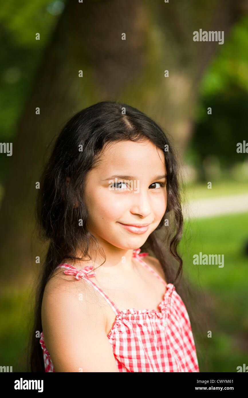 Lächelnde dunkelhaarige Mädchen draußen, Porträt Stockfoto