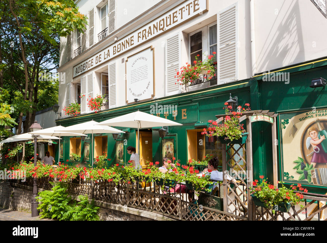 Leute sitzen in einem Straßencafé Restaurant unter Sonnenschirmen in Montmartre Paris Frankreich EU Europa Stockfoto
