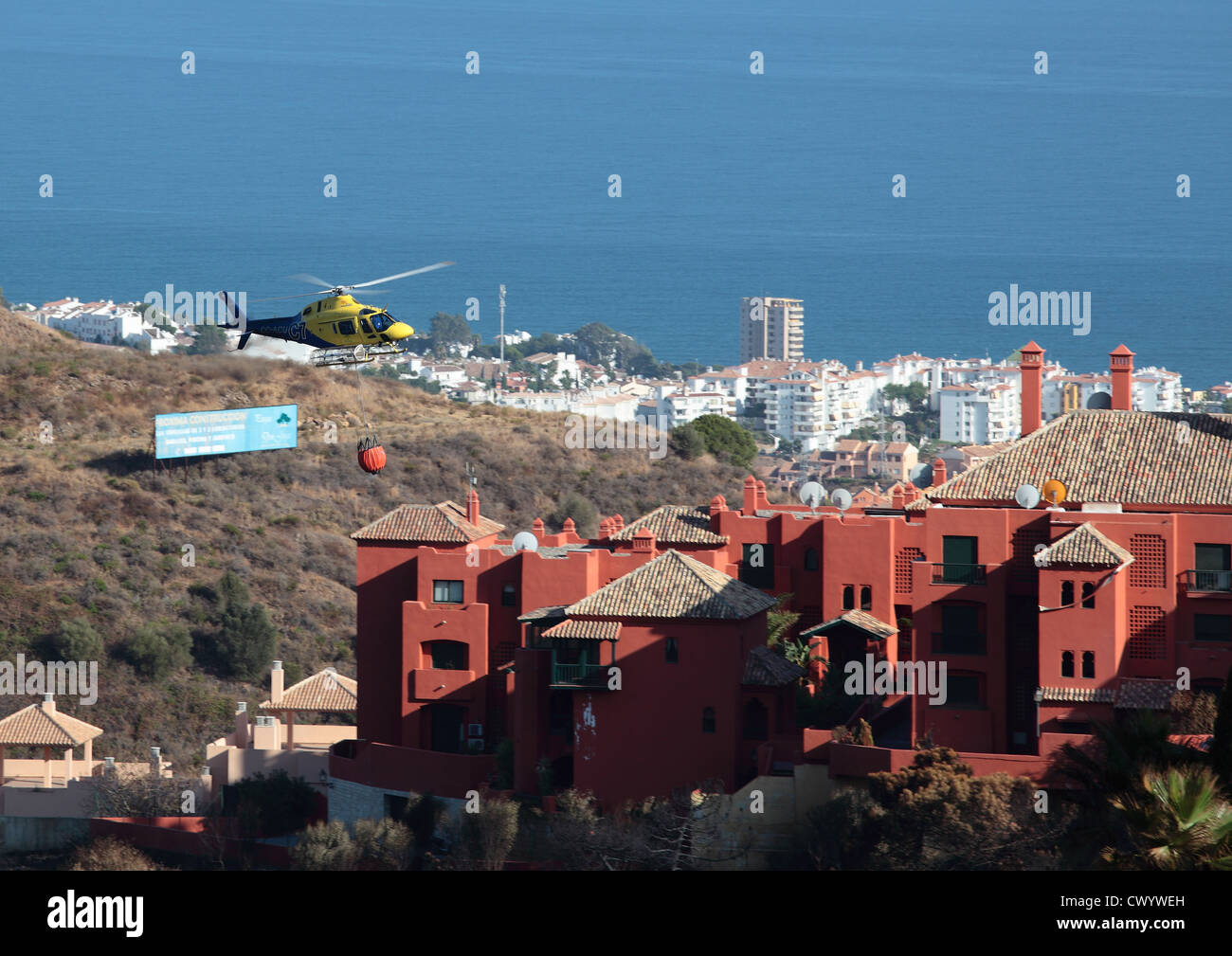Feuer Hubschrauber fliegen über Wohnungen nach Waldbrände an der Costa Del Sol Stockfoto