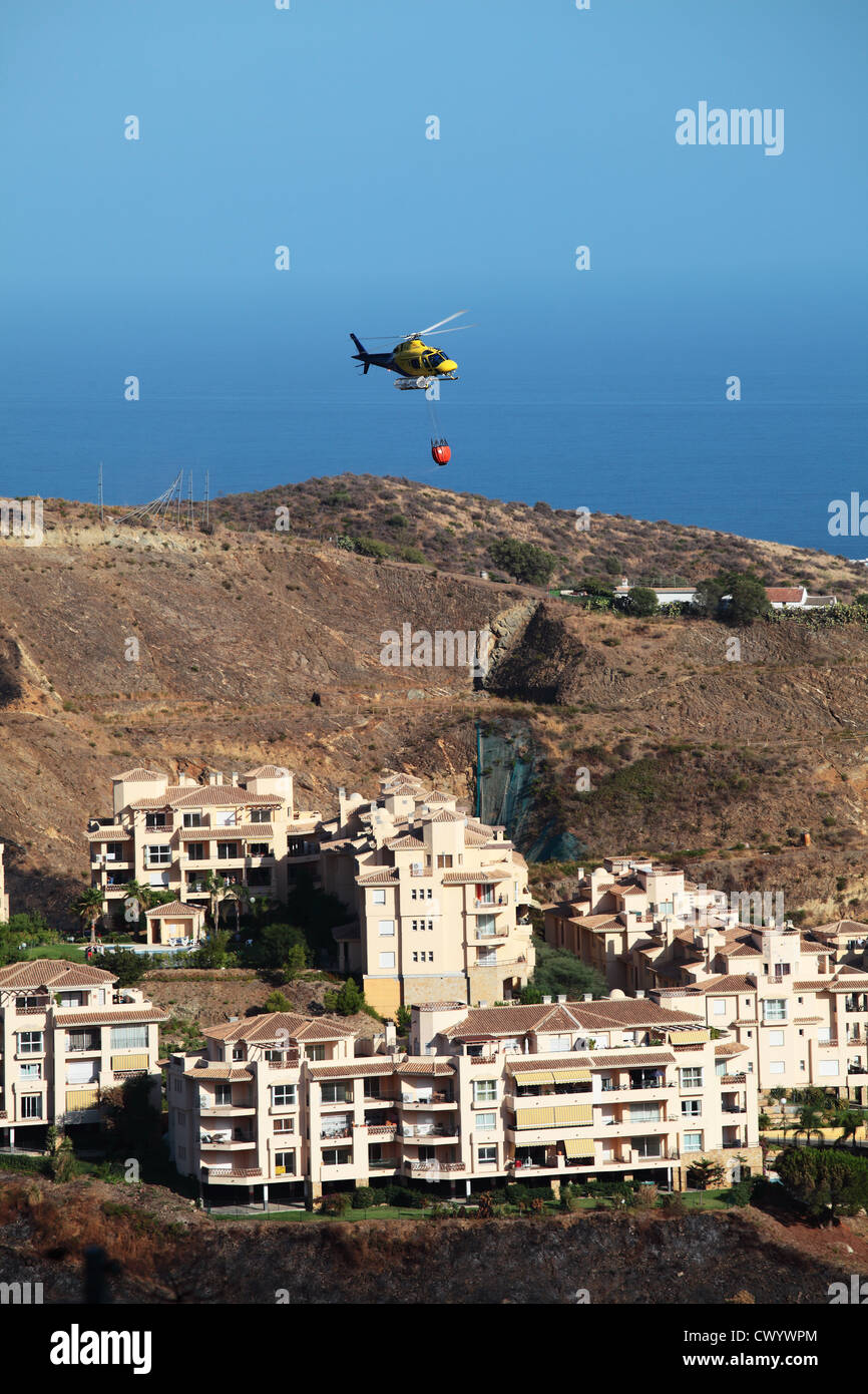 Feuer Hubschrauber fliegen über Wohnungen nach Waldbrände an der Costa Del Sol Stockfoto