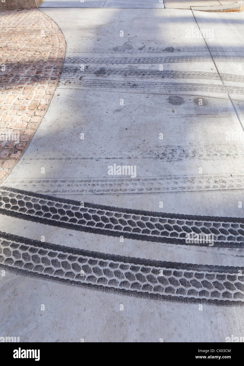 Reifenspuren auf Bürgersteig Stockfoto