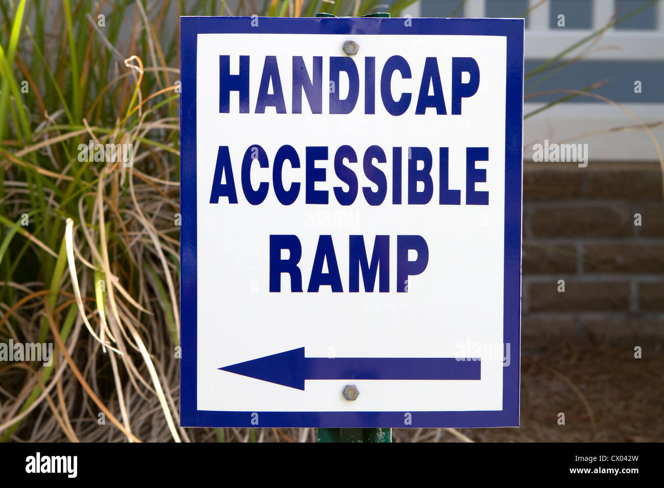 Zeichen vor einem Gebäude weist auf eine Behinderte zugängliche Rampe für die Nutzung durch Menschen mit Behinderungen. Stockfoto