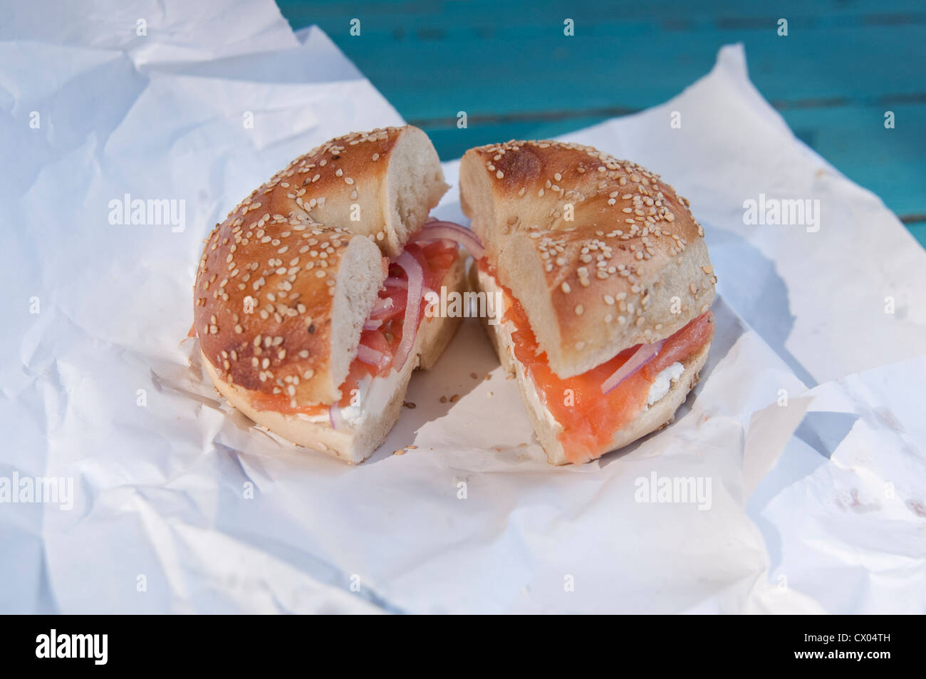 Ein Sesam Bagel mit Lox (Lachs), Frischkäse, Zwiebel und Tomate, sitzen auf einem Papier Verpackung, ab Frühjahr Baum Bagels in Englewood, NJ. Stockfoto