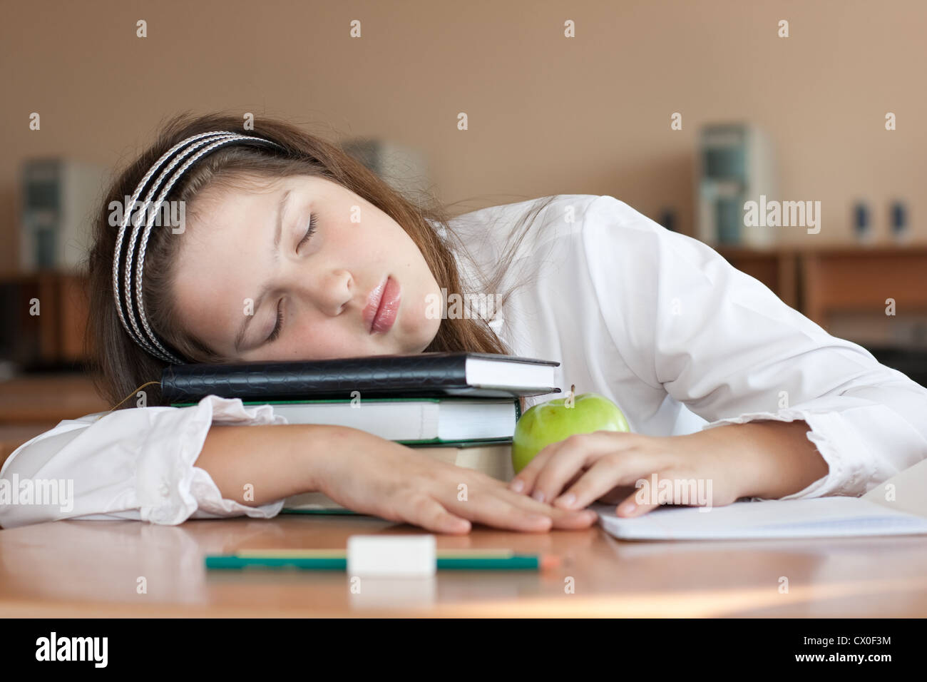 Schülerin schläft mit ihren Büchern im Unterricht Stockfoto