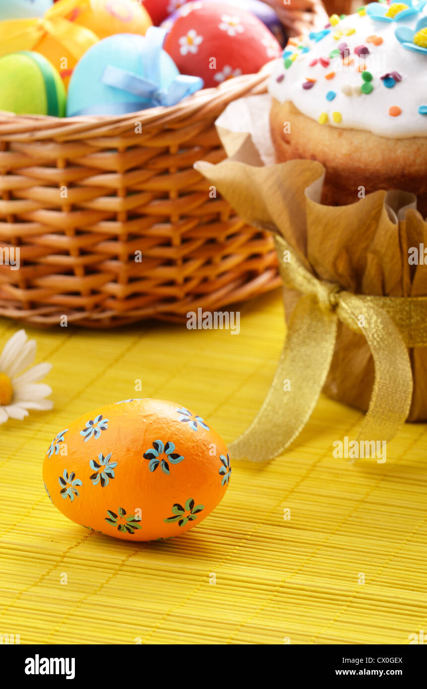 Osterdekoration - Eiern, Kuchen und Korb auf der Tischplatte Stockfoto
