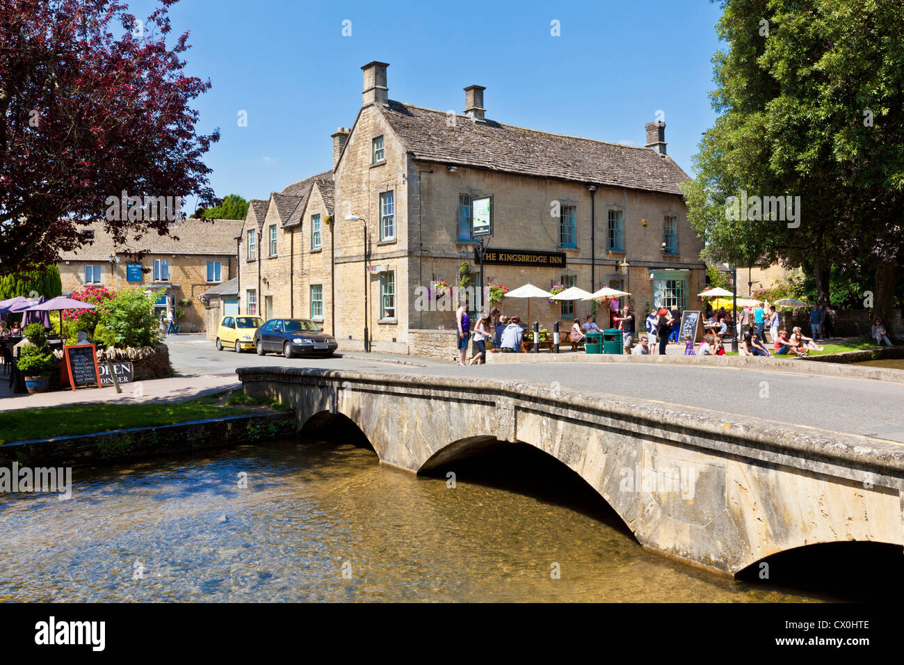 Cotswolds Dorf mit einer alten Steinbrücke über den Fluss Windrush durchkämmt das Zentrum von Bourton am Wasser Gloucestershire England GB Europa Stockfoto