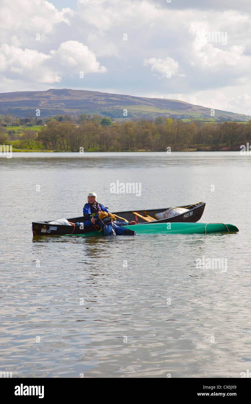 Kanu Rettung Praxis Mann Unfall in kanadisches Kanu zu heben. Talkin Tarn in der Nähe von Brampton, Cumbria, England Stockfoto