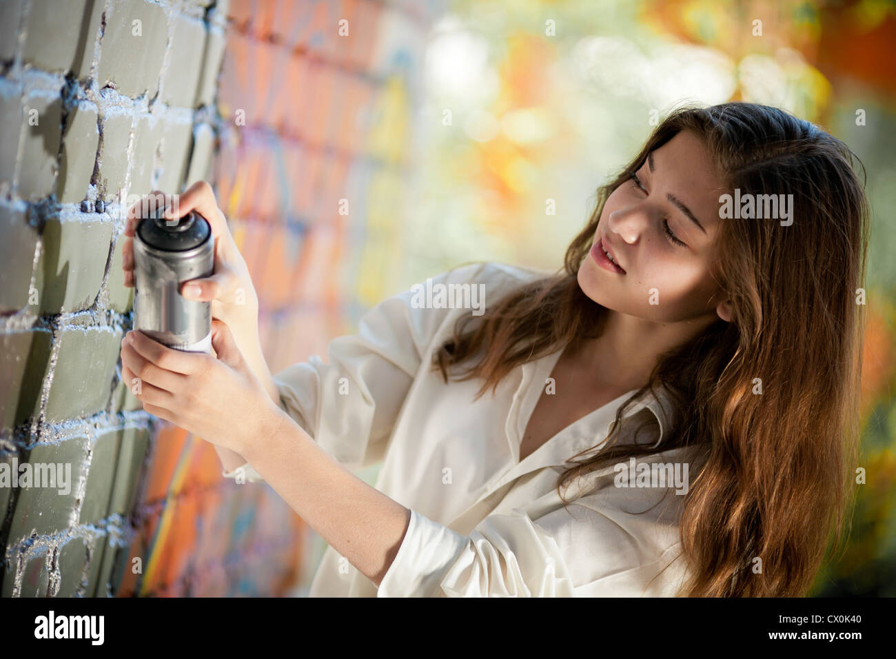 Teenager-Mädchen Porträt mit Spray kann Graffitiwand in der Nähe. Stockfoto