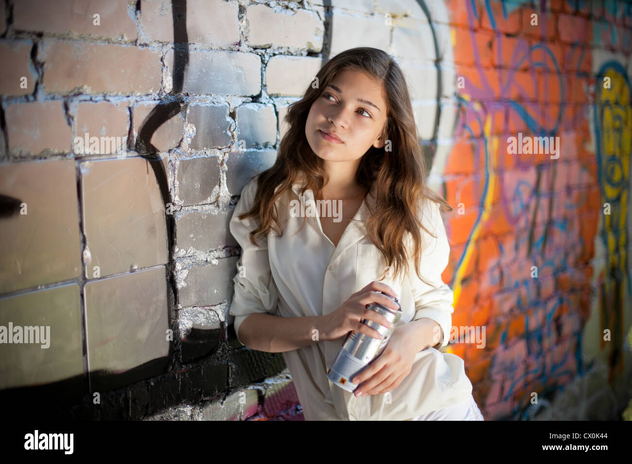 Teenager-Mädchen Porträt mit Spray kann Graffitiwand in der Nähe. Stockfoto