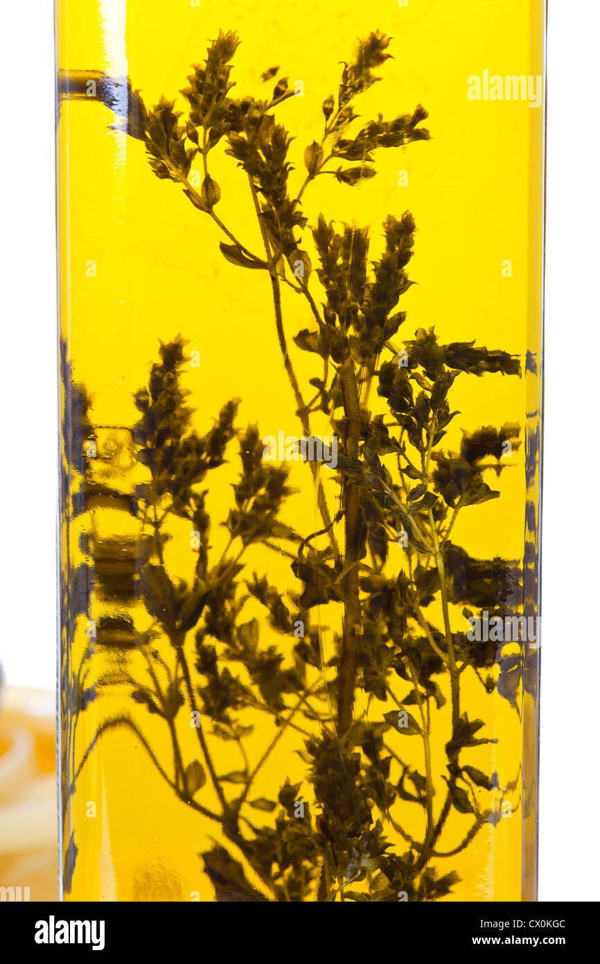 Olivenöl in Glasflasche mit Kräuter Oregano in Makro Stockfoto