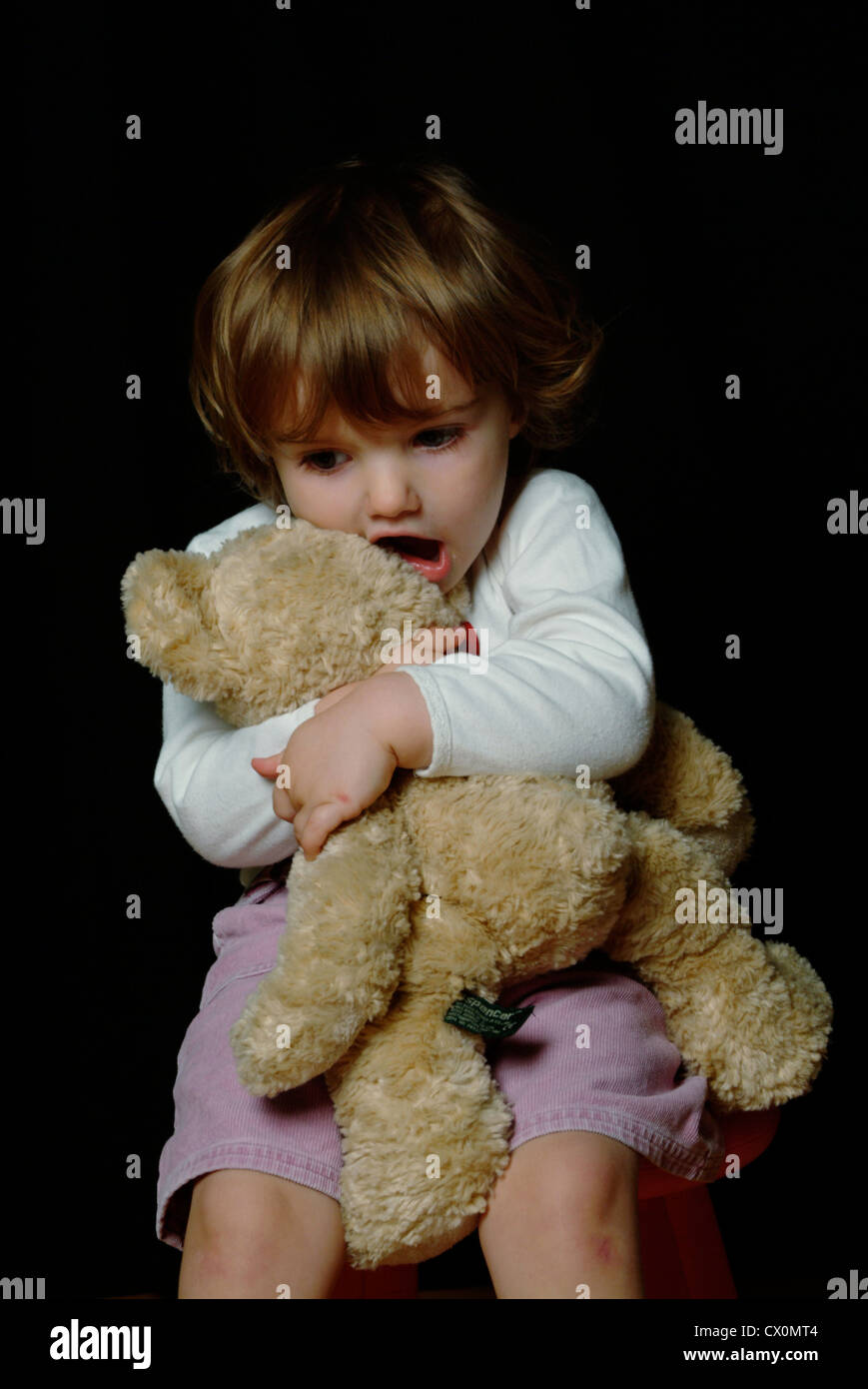 Kleines Mädchen kuscheln einen Teddybär Stockfoto