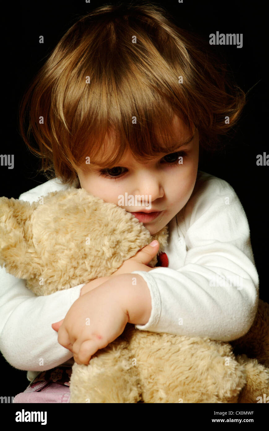 Kleines Mädchen kuscheln einen Teddybär Stockfoto