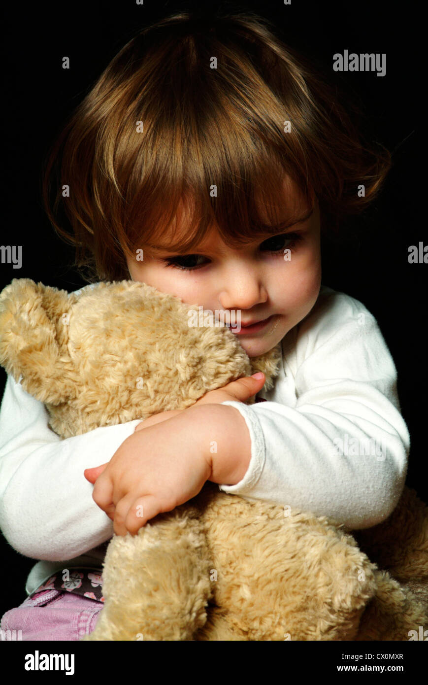 Kleine weiße Mädchen Kuscheln ein Teddybär Stockfoto