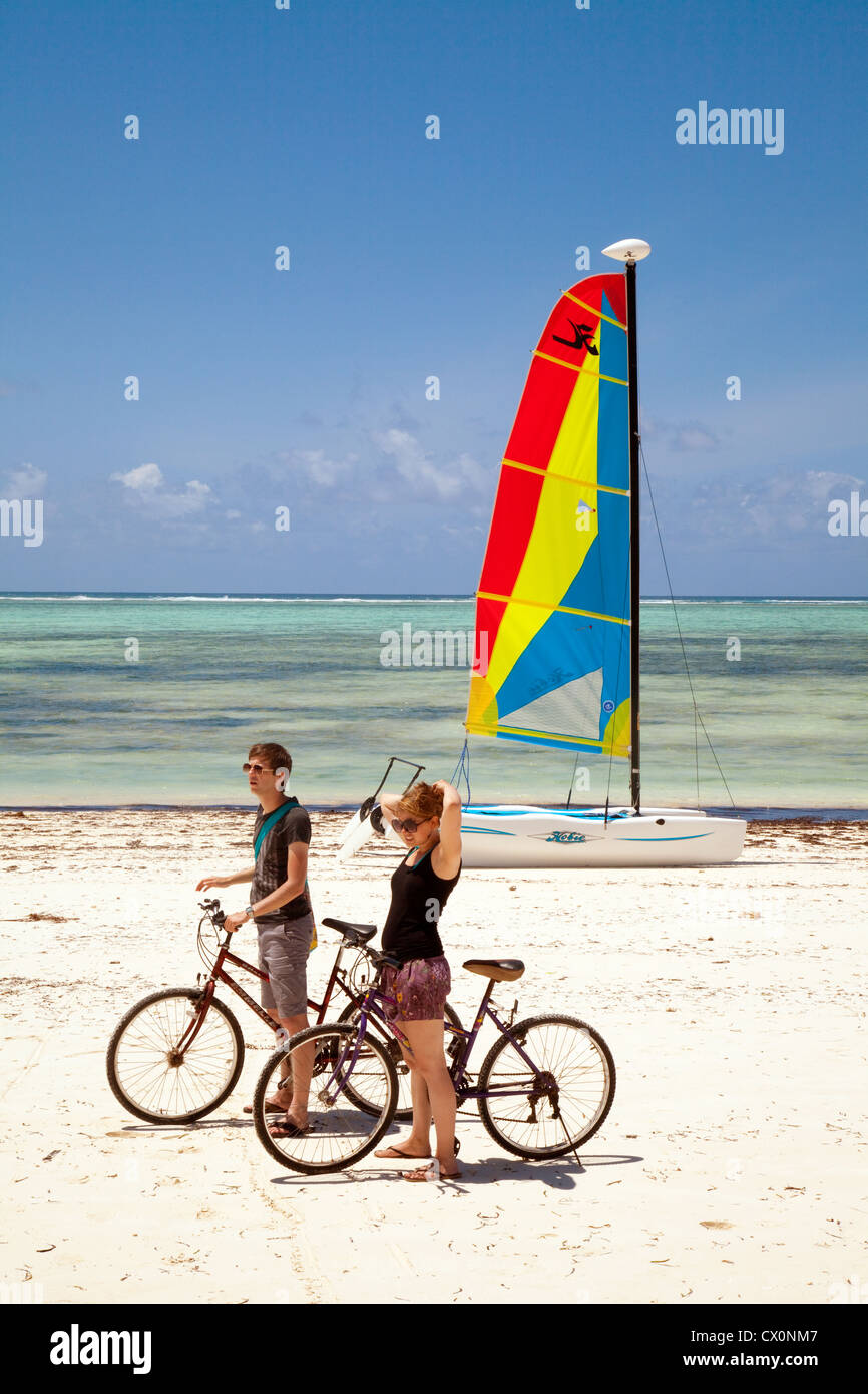 Sansibar-Urlaub, EIN Paar radeln am Strand im Urlaub, Sansibar-Afrika; Beispiel für Afrika-Tourismus Stockfoto
