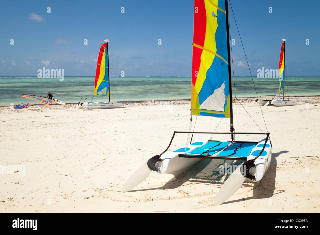 Drei Hobie Cat Katamarane und ein Windsurfer am Strand von Bwejuu, Zanzibar Afrika Stockfoto
