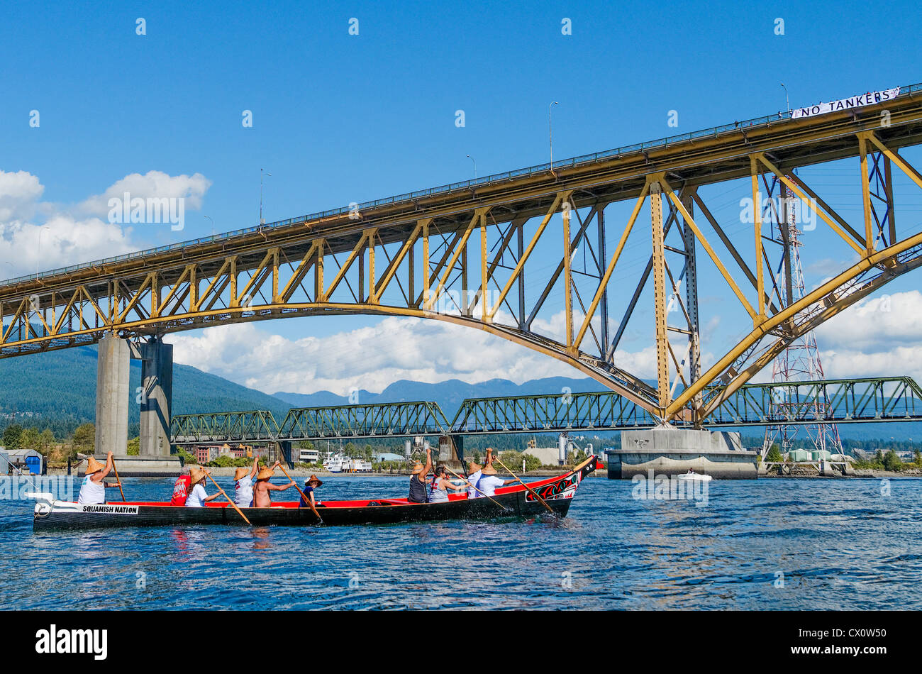 Squamish First Nations Kanu nähert sich Arbeitnehmer Memorial Eisenbrücke mit No Tanker Schild Stockfoto