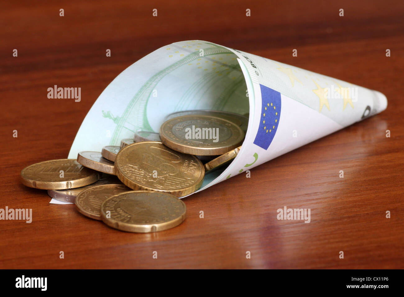 Euro-Münzen in gerollten 100 Euro-banknote Stockfoto