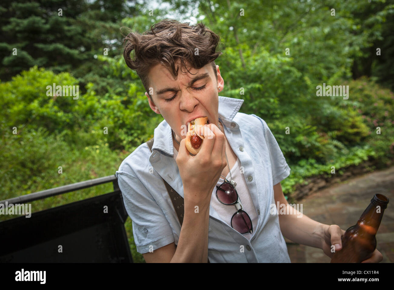 Junger Mann isst einen hotdog Stockfoto