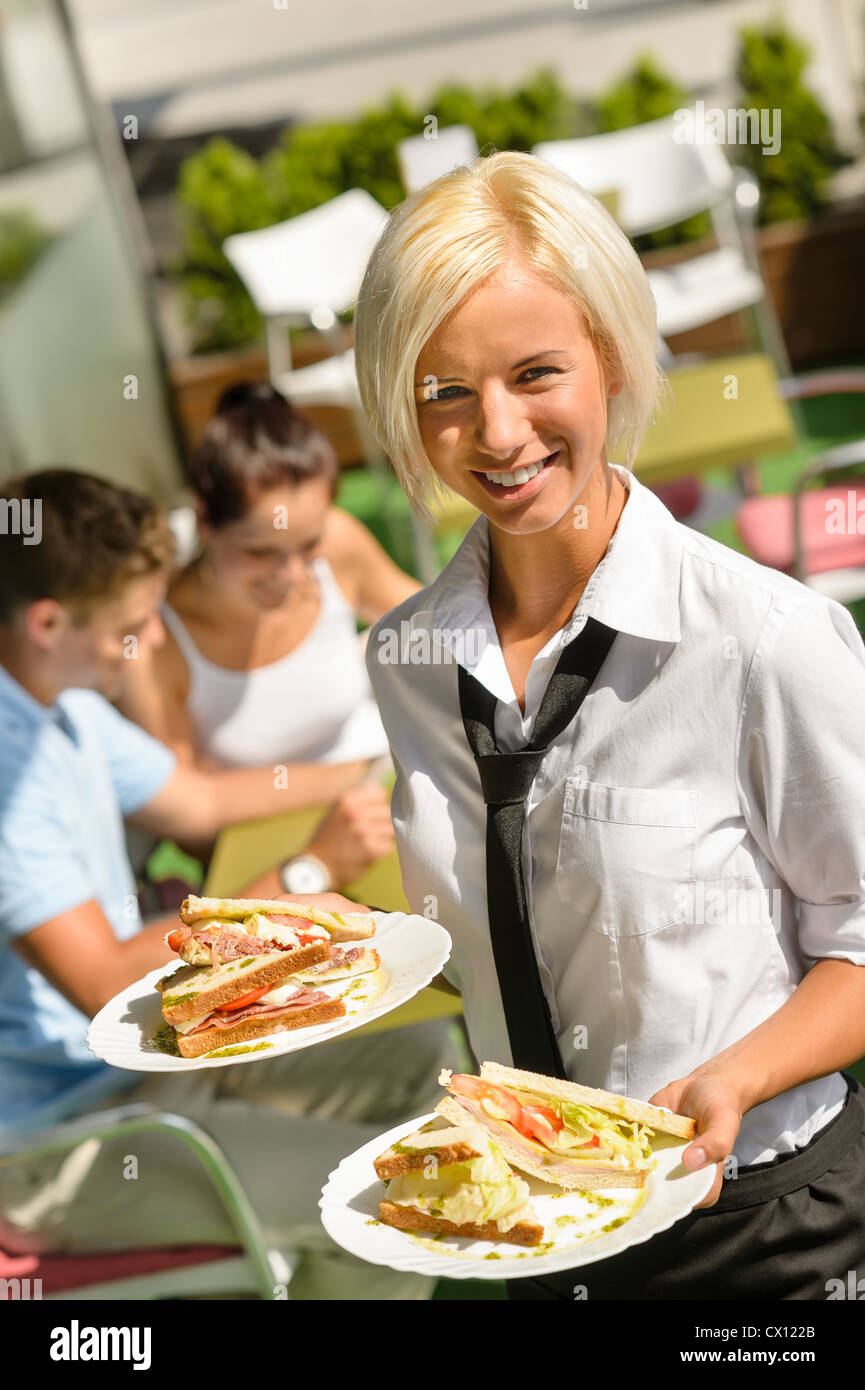 Kellnerin bringt Sandwiches auf Platten frisches Mittagessen Restaurantterrasse Stockfoto