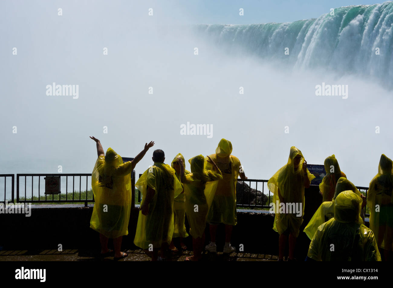 Touristen in gelb wasserdicht Ponchos auf der Aussichtsplattform am Fuße des Niagara Falls, Kanada gekleidet. Stockfoto