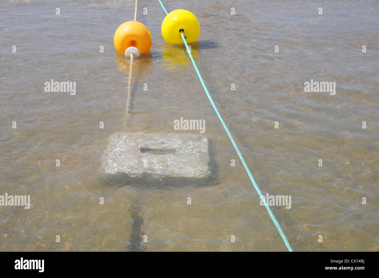 Gelb und orange hin-und Herbewegungen und Seil, Betonklotz unter Wasser, Meer, Strand, Costa De La Luz. Stockfoto