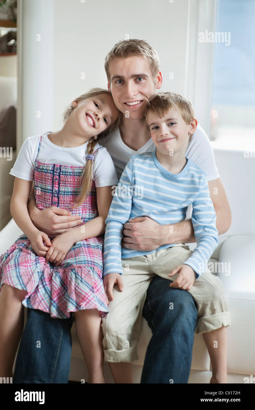 Porträt der Kinder sitzen auf Vaters Schoß Stockfoto