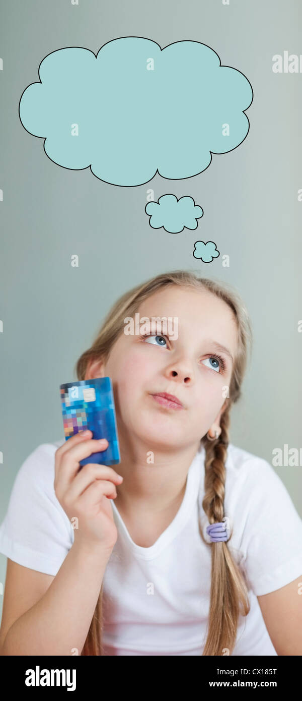 Nachdenklich junges Mädchen hält Kreditkarte mit Sprechblase über grauen Hintergrund Stockfoto