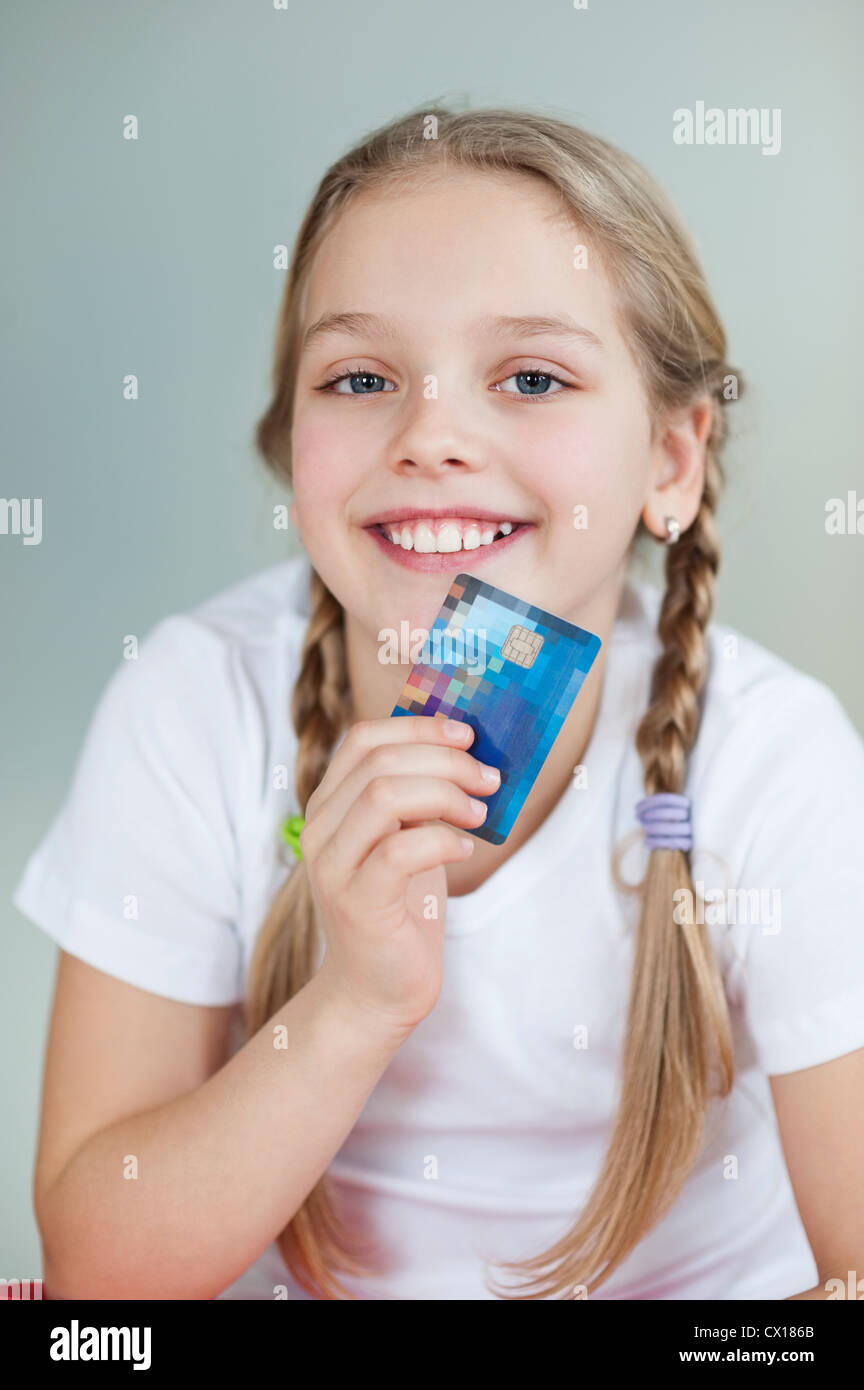 Porträt eines Mädchens mit Kreditkarte über grauen Hintergrund Stockfoto
