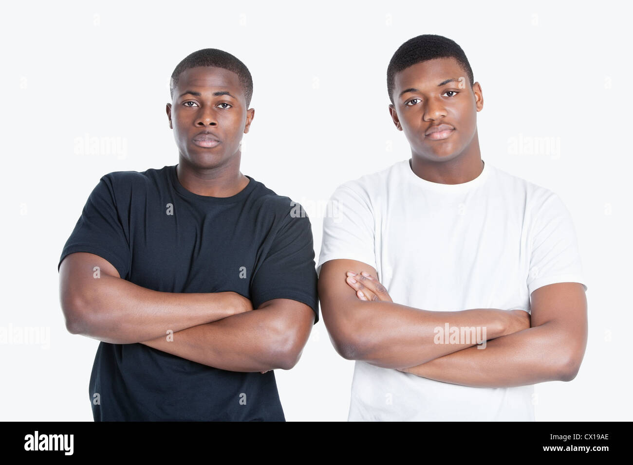 Porträt von zwei afroamerikanische männliche Freunde mit verschränkten über grauen Hintergrund Stockfoto