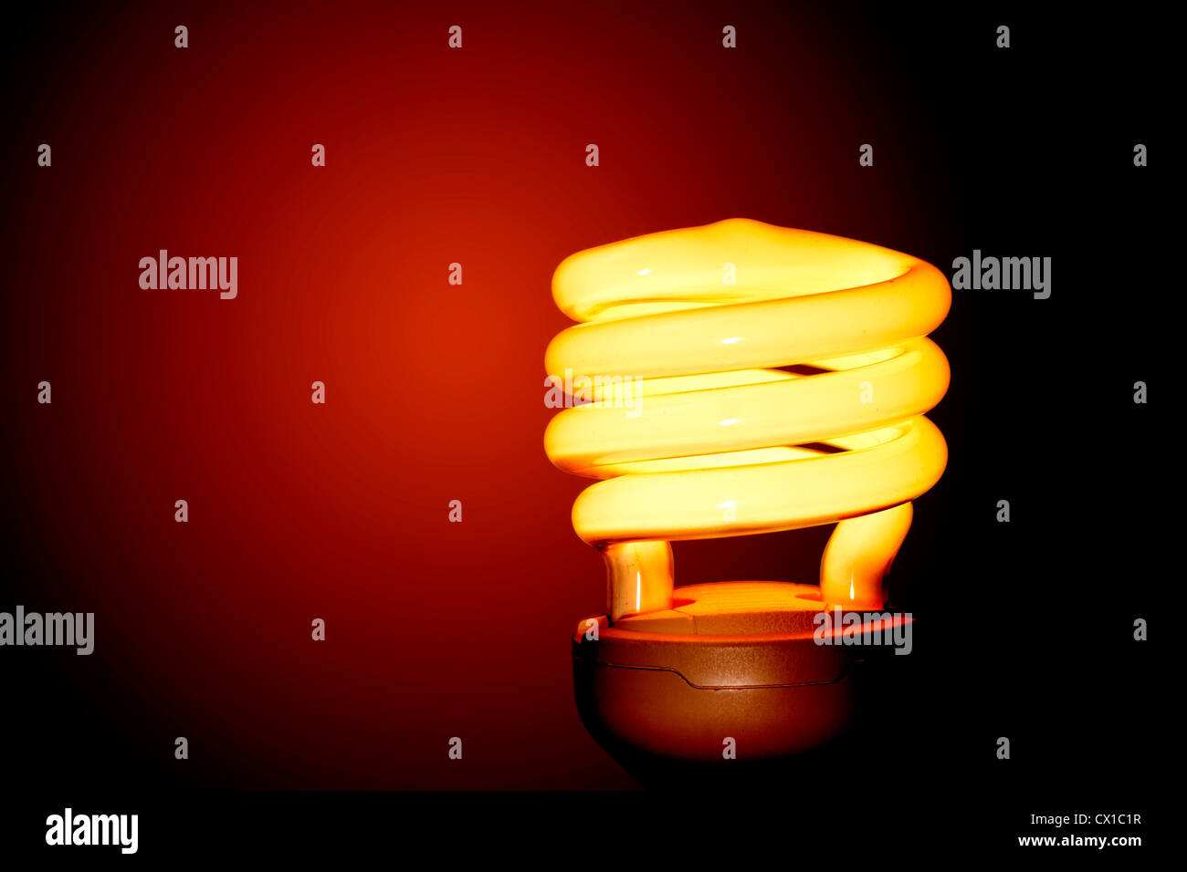 Energiesparende Glühbirne auf rotem Grund. Stockfoto