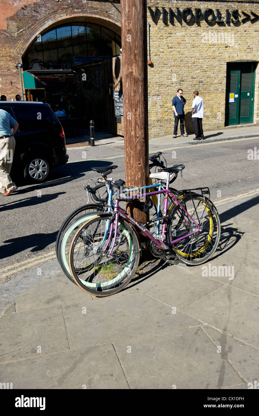Fahrräder an einen hölzernen Telegrafenmast gesichert Stockfoto