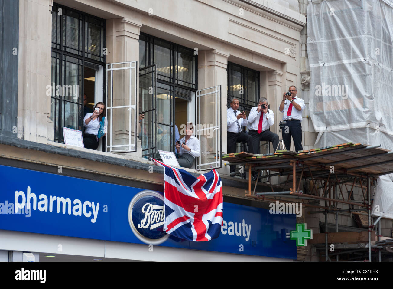 Zuschauer beobachten aus einem Büro bei Siegesparade der London Olympics 2012 Team GB London UK Stockfoto