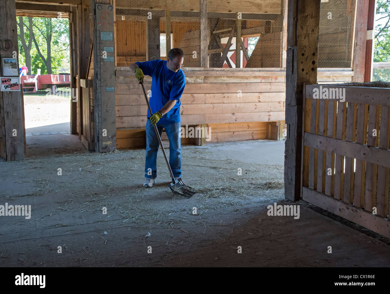 Ein Freiwilliger aus Ford Motor Co. reinigt eine Scheune bei Maybury-Farm, ein pädagogischer Bauernhof für Kinder und Familien Stockfoto