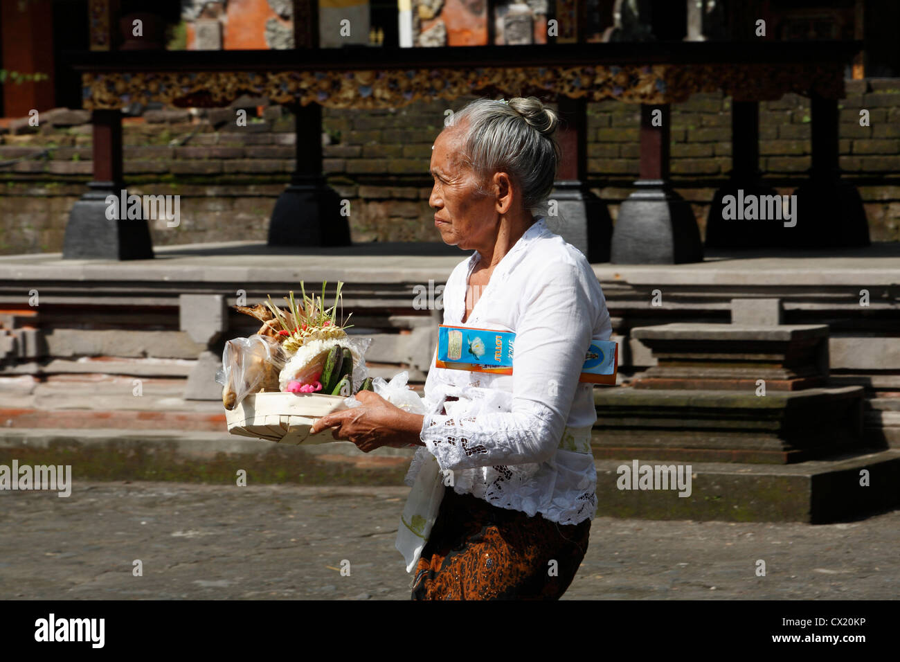 Eine ältere balinesische Frau kommt im Tempel mit ihren angeboten und Weihrauch. Pura Tirta Empul oder Heiligen Frühling Tempel Stockfoto