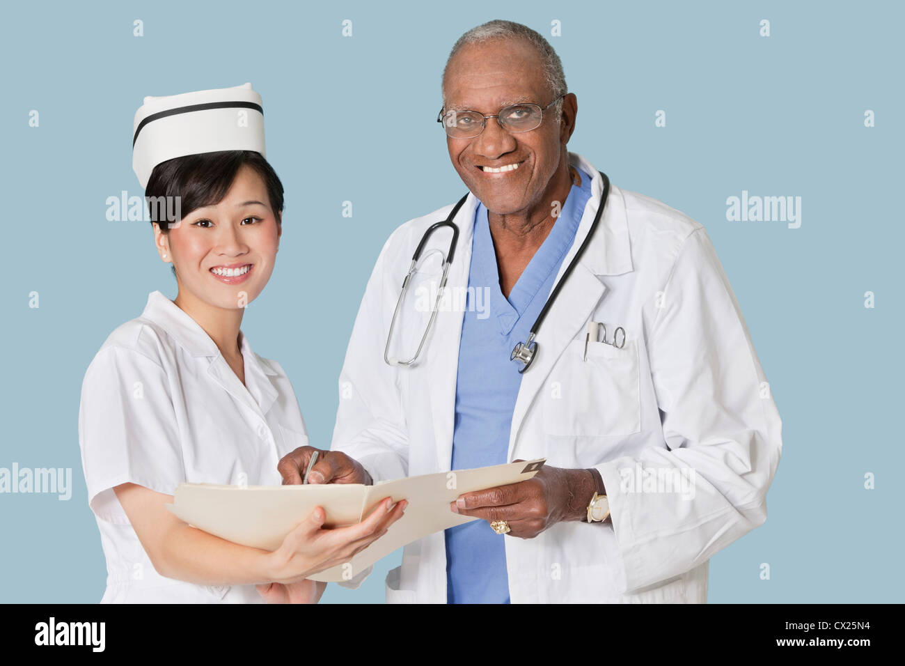 Porträt von glücklich Fachkräfte des Gesundheitswesens mit medizinischen Bericht über hellblauen Hintergrund Stockfoto