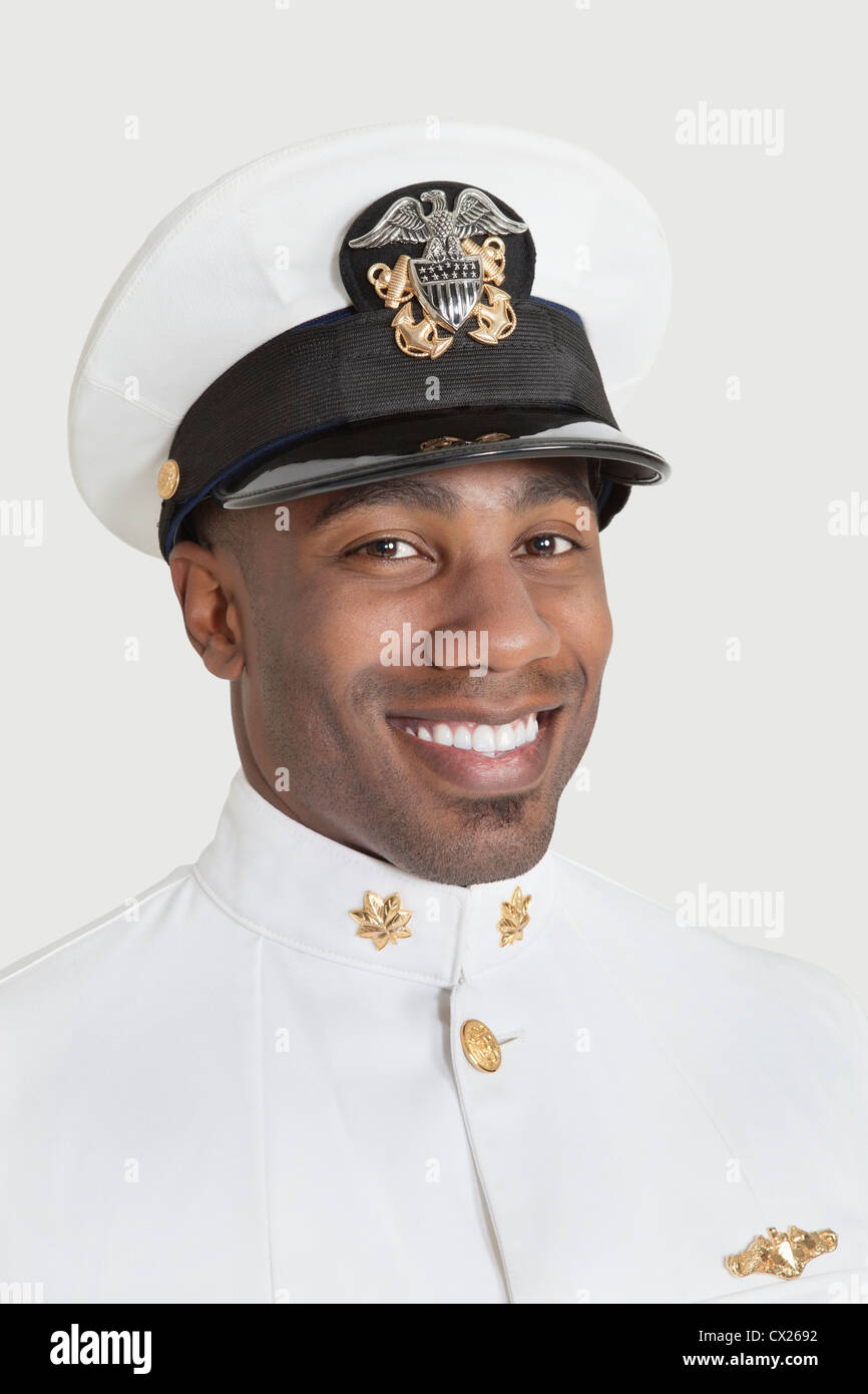 Porträt von glücklich junger afrikanischer Amerikaner US Navy Offizier auf grauem Hintergrund Stockfoto