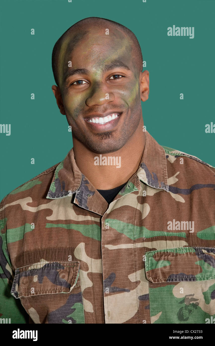 Porträt eines afroamerikanischen männlichen US Marine Corps-Soldaten mit getarnten Gesicht auf grünem Hintergrund Stockfoto