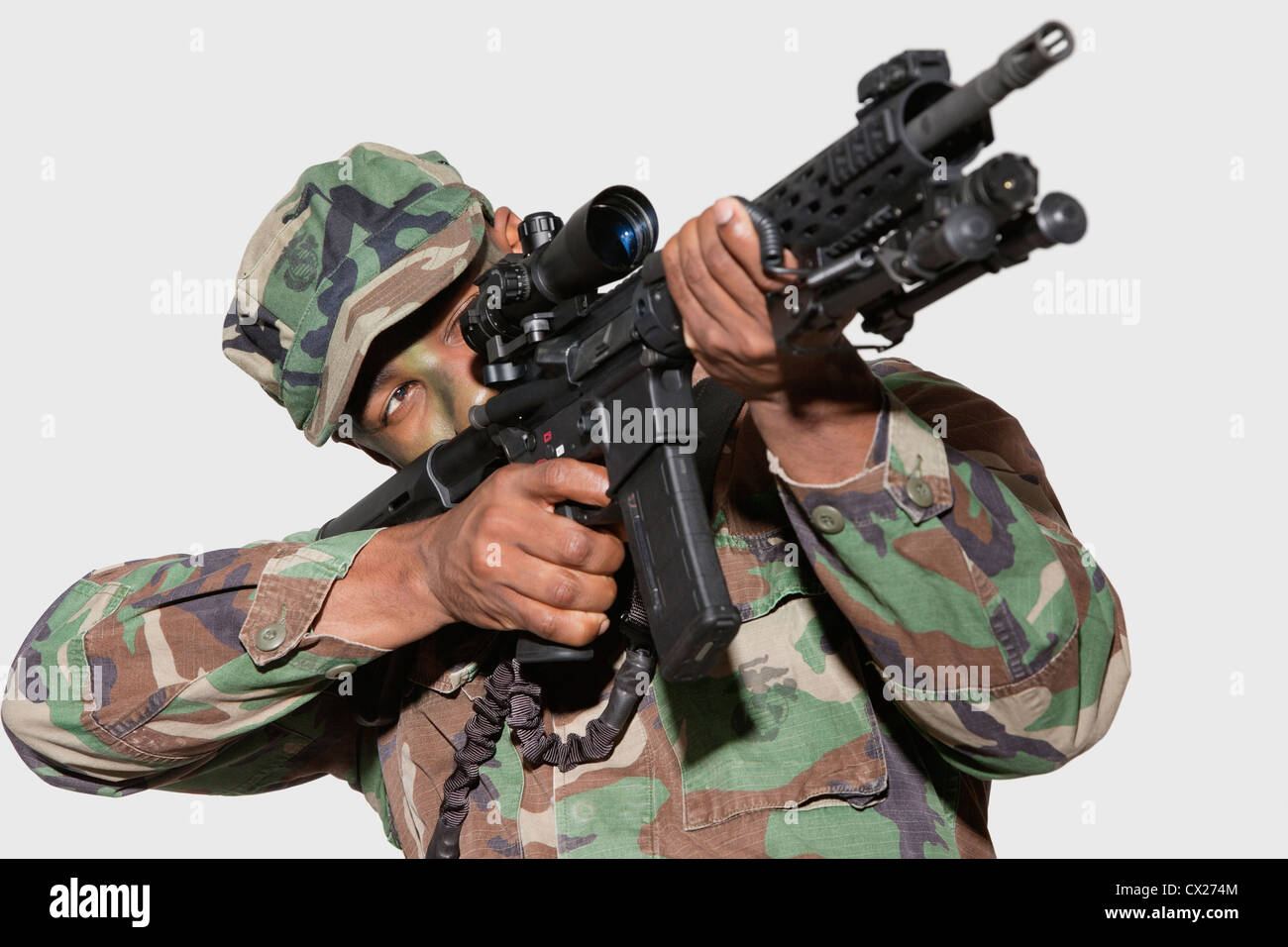 US Marinekorps-Soldat mit dem Ziel M4-Sturmgewehr vor grauem Hintergrund Stockfoto