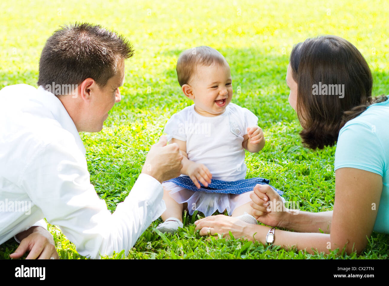 glückliche junge Familie draußen im park Stockfoto