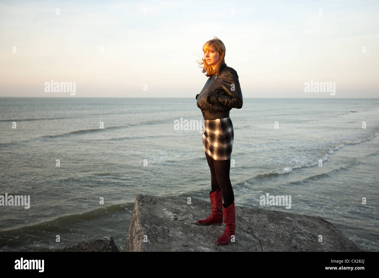 Blonde Mädchen den Sonnenuntergang am Meer Stockfoto